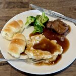 Plate with rolls, mashed potatoes, gravy, broccoli, and roast beef